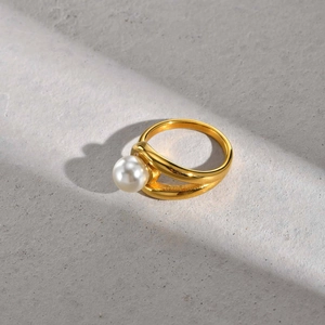 Detail of 18K gold-plated double-layer ring featuring a white faux pearl on stone background