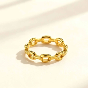 Detailed close-up of a polished gold chain link ring with geometric oval links