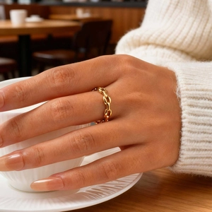 Close-up of a gold chain ring on a finger, featuring a minimalist link design in metal