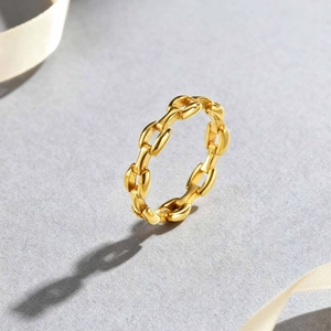 Modern gold-plated stainless steel chain link ring displayed on a minimalist background
