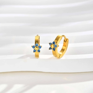 Orecchini a cerchio dorati con fiore in zircone blu su elegante espositore bianco