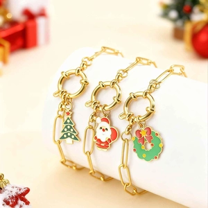 Détail de bracelets de Noël avec breloques sapin et Père Noël sur chaînes dorées