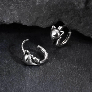Detail of silver fox hoop earrings with vintage texture on a dark stone background