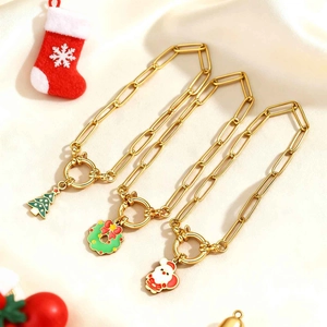Détail des breloques de Noël avec Père Noël et sapin sur une chaîne à trombone dorée