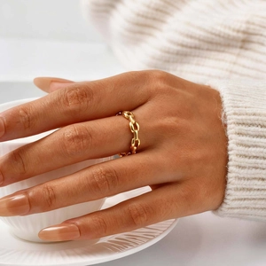 Polished gold stainless steel chain ring shown on hand with elegant white background