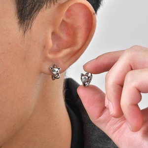 Detailed view of silver fox earrings with white zircon on a model for scale