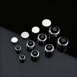 Macro shot of polished silver metal screw covers with black zircon inlay in various sizes