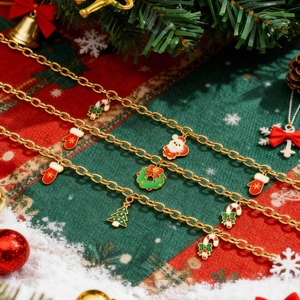 Detail der goldenen Festarmbänder mit Emaille-Anhängern wie Weihnachtsmann und Baum auf Hintergrund