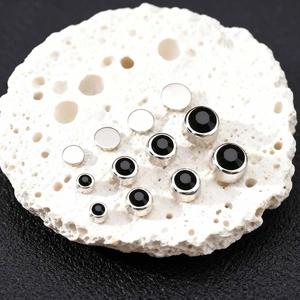 Vintage black zircon ear clips set in various sizes on a white stone and leather base
