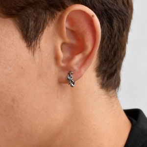 Detail shot of a silver fox-shaped hoop earring with a white zircon worn on the ear