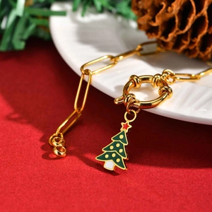 Vue détaillée d'une chaîne dorée avec un pendentif festif en forme de sapin de Noël vert