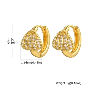Vue détaillée des boucles d'oreilles créoles dorées avec motif coquillage et zircones