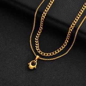 Dettaglio della collana dorata a due strati con mano di Fatima e catena cubana