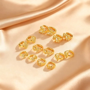 Collection de boucles d'oreilles dorées avec tournesol et papillon sur tissu de soie