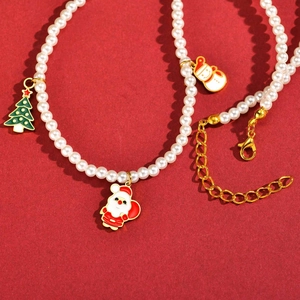 Détail du collier de perles de Noël avec breloques émaillées Père Noël, sapin et bonhomme de neige