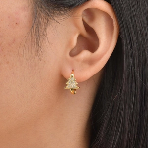 Gros plan de boucles d'oreilles sapin de Noël dorées avec zircons portées par un mannequin
