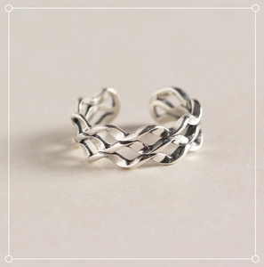 Detailed macro view of retro wavy S925 sterling silver triple layer mobius ring