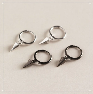 Macro shot of silver and black geometric cone hoop earrings on a matte background