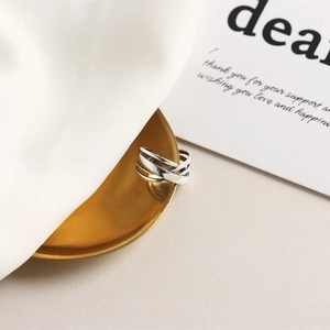 Macro detail of a multilayer S925 sterling silver ring on a golden plate and silk
