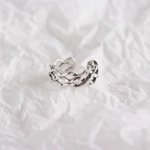 Close-up of vintage s925 silver woven multilayer ring with oxidized finish on paper
