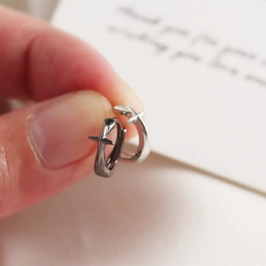 Vue détaillée de boucles d'oreilles créoles en argent S925 avec étoile en main