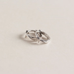 Détail macro de boucles d'oreilles en argent S925 avec motif étoile et fini poli