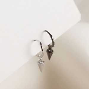 Detail of silver and gun black geometric cone pendant earrings in minimalist style