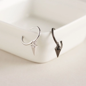 Detailed view of silver and black geometric cone pendant hoop earrings in minimalist style