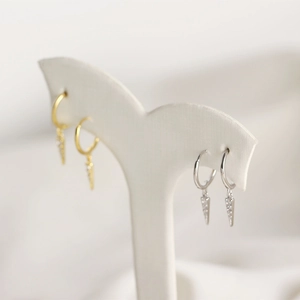 Detail of silver and gold triangle hoop earrings with sparkling cubic zirconia stones
