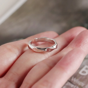 Close-up of S925 sterling silver twisted ring with polished irregular wave design