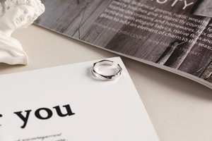 Macro detail of a twisted 925 sterling silver minimalist ring on a high-end prop setting