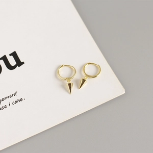 Detail view of gold S925 sterling silver geometric hoop earrings with punk spike pendants