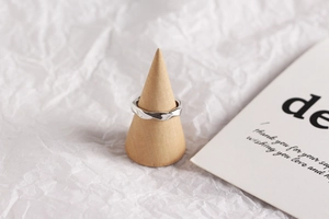 Close-up of a s925 sterling silver twisted ring displayed on a wooden cone stand