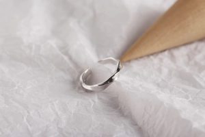 Detailed macro view of minimalist S925 sterling silver twisted Möbius open ring design