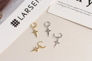 Close-up of gold and silver S925 sterling silver four-point star hoop earrings set