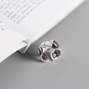 Macro detail of braided silver Cuban chain link ring with adjustable open band design