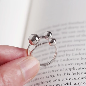 Macro view of minimalist S925 sterling silver ring featuring three polished round beads