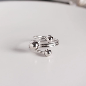 Detail view of multi-layer spiral S925 silver ring with polished triple bead accents