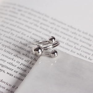 Detail shot of s925 sterling silver triple spiral ring with beads on marble surface