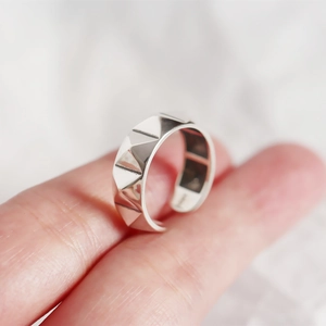 Gros plan d'une bague en argent S925 avec design rivet géométrique et poinçon interne