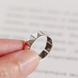 Vue macro d'une bague en argent S925 avec motif géométrique de clous pyramide