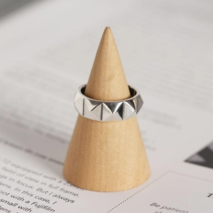 Vue macro d'une bague en argent S925 avec clous rivets de style punk et géométrique