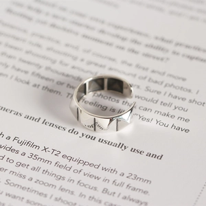 Macro d'une bague rivet en argent S925 avec texture pyramide punk sur un livre ouvert