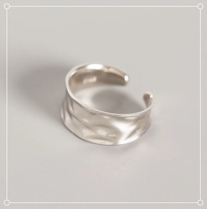 Macro detail of S925 sterling silver ring showing irregular hammered texture and hallmark