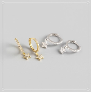 Détail macro de boucles d'oreilles créoles étoiles en argent S925 doré et argenté avec zircons