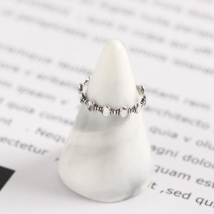 Vintage S925 sterling silver geometric ring with beaded oval discs on a marble stand