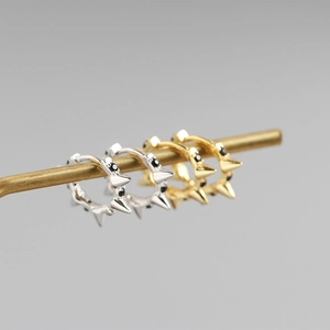 Détail de boucles d'oreilles créoles punk en argent S925 avec rivets et zircons noirs