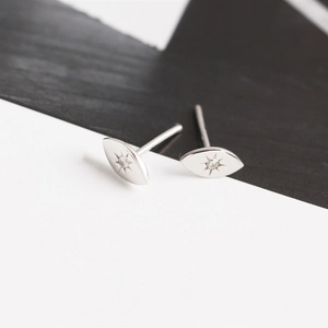 Macro detail of S925 sterling silver evil eye stud earrings with starburst engraving