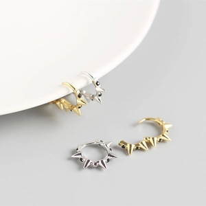 Vue détaillée des boucles d'oreilles punk en argent S925 avec rivets et pierres noires