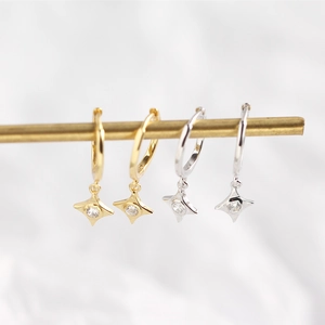 Detail view of gold and silver S925 sterling silver hoop earrings with star charms